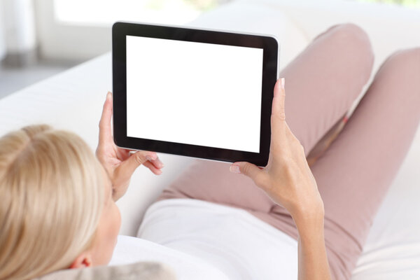 woman sitting on sofa using tablet