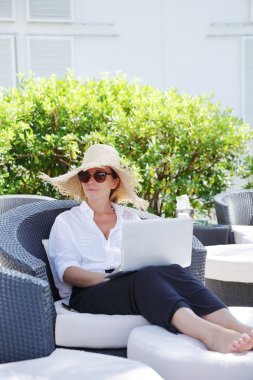 woman sitting outdoors with laptop