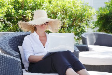 woman sitting outdoors with her laptop