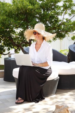 woman sitting outdoors with her laptop
