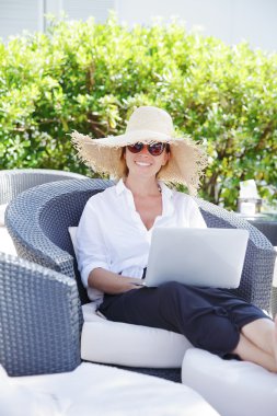 woman sitting outdoors with laptop