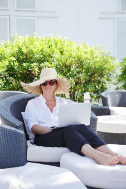 woman sitting outdoors with laptop
