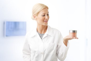 beauty specialist holding bowl of cream