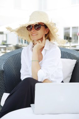 woman sitting outdoors with laptop