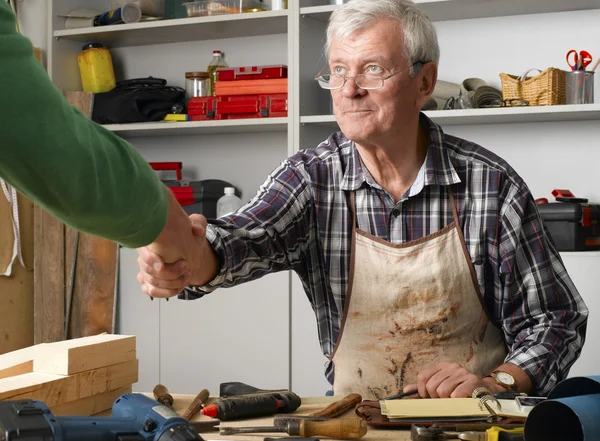 Mann in Werkstatt schüttelt Geschäftsmann die Hand — Stockfoto