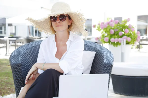 Woman sitting outdoors with laptop — Stockfoto