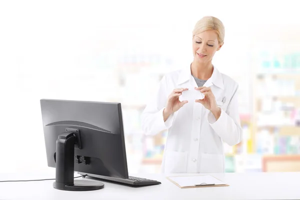 Pharmacist standing at working desk — Stockfoto