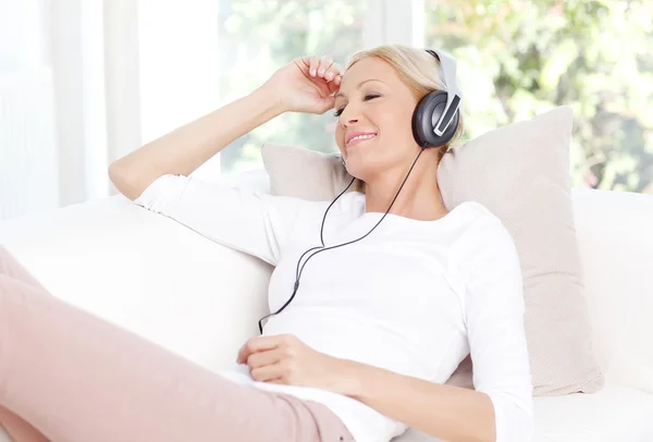 Женщина расслабляет слушая музыку с наушниками — стоковое фото