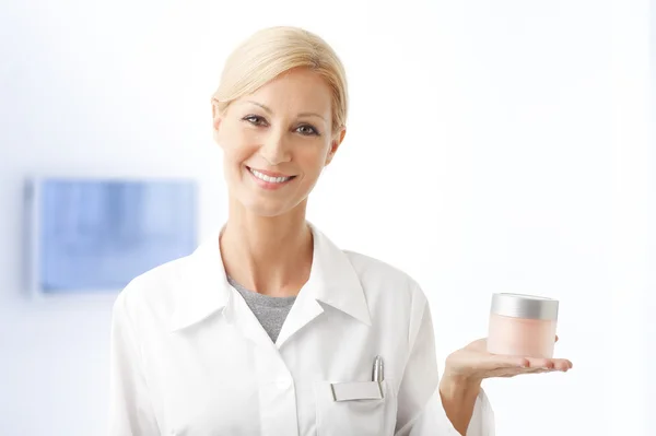 Beauty therapist holding jar of cream — Zdjęcie stockowe