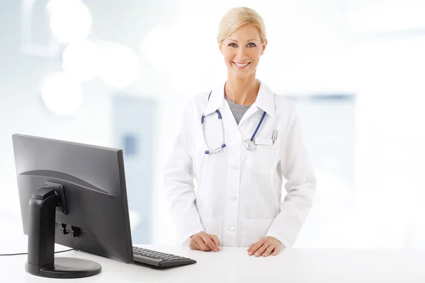 Female doctor standing in front of computer — 스톡 사진