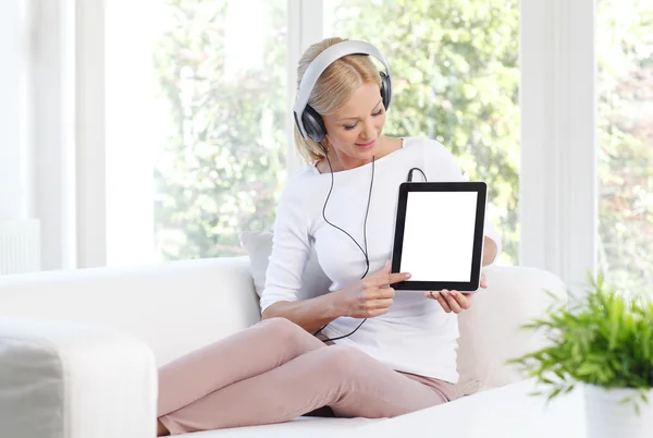 Woman with headphone sitting at living room — Stockfoto