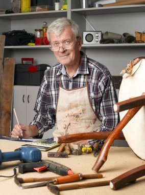 retired manual worker working at workshop