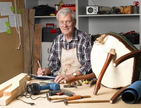 Retired manual worker working at workshop — ストック写真