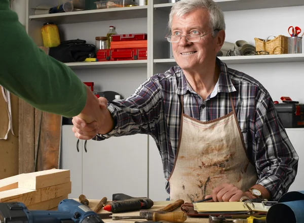 Professional man in workshop shaking hands with businessman — Φωτογραφία Αρχείου