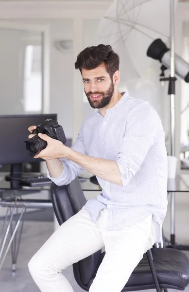 Photographer sitting holding an old camera — Stock Photo, Image