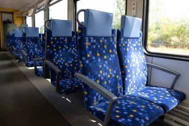 Boş tren vagonunda mavi desenli koltuklar ve pencereler