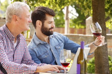 winemakers sitting at desk in front of laptop