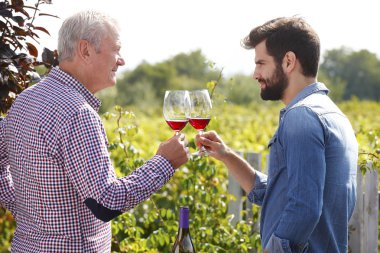 winemakers toast with red wine