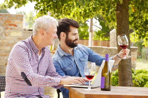 Winemakers sitting at desk in front of laptop — 图库照片