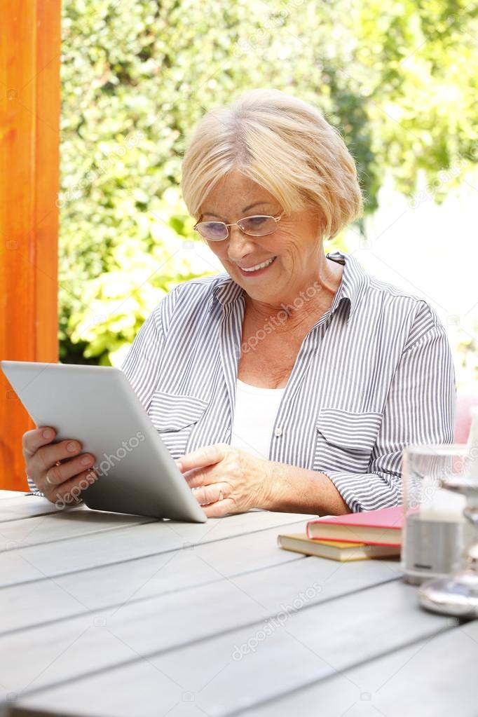 retired woman holding tablet