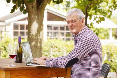 winemaker at vineyard in front of laptop clipart