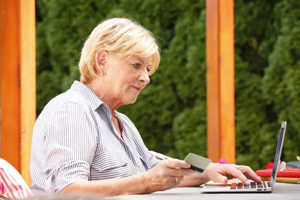 Senior kobiety w ogrodzie z laptopa — Zdjęcie stockowe