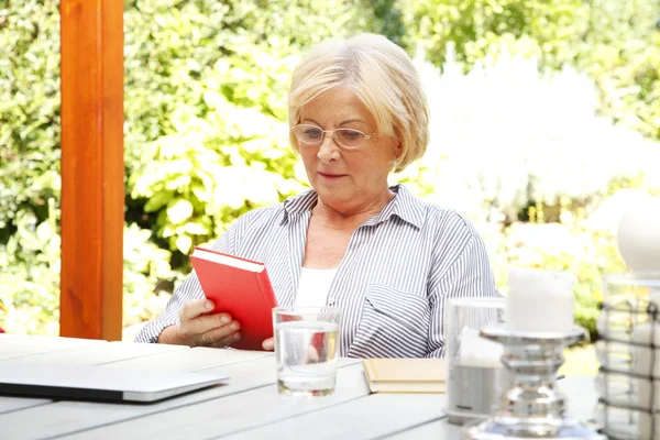 Старшая женщина читает книгу — стоковое фото