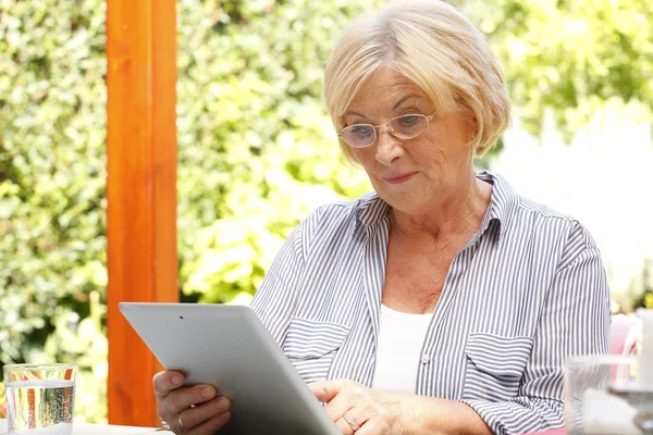 Pensionerad kvinna med tablett — Stockfoto
