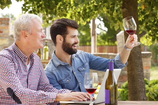 Jeunes et seniors dégustation de vin rouge — Photo