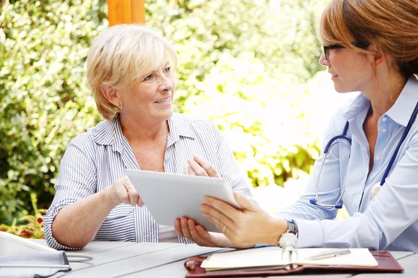 Seniorin mit Pflegerin im Garten — Stockfoto