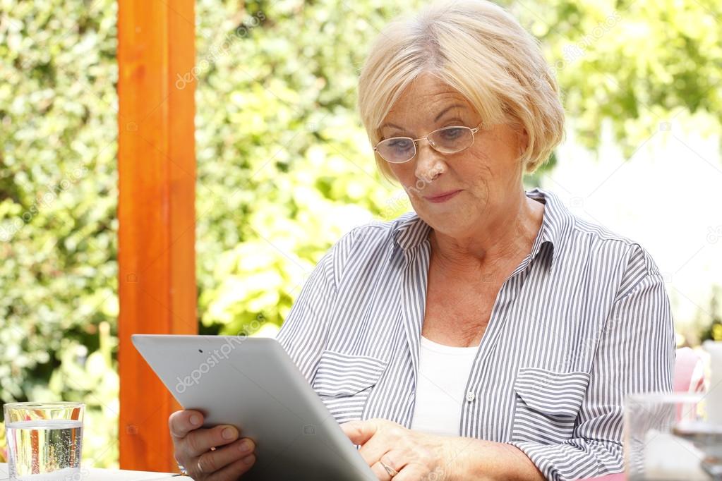 retired woman holding tablet