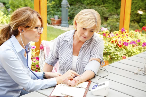 Home caregiver sitting at home — Stockfoto