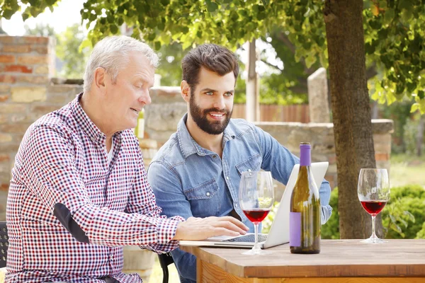 winemakers sitting in front of laptop