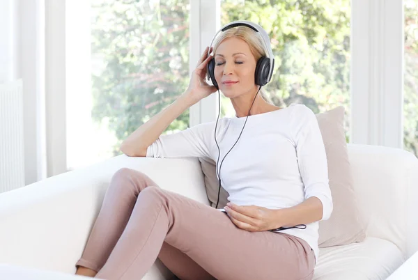 Woman with headphones relaxing at home — 스톡 사진