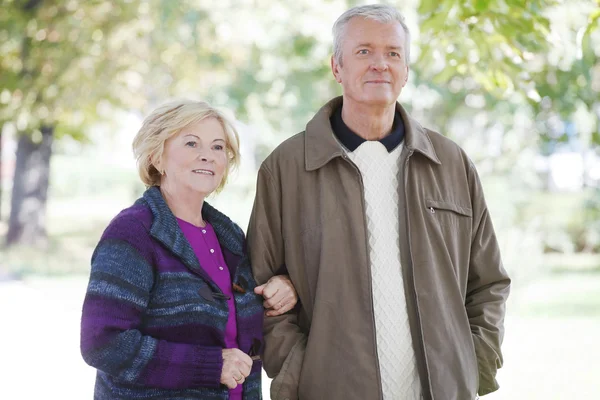 Senior couple strolling through the park — Stock Photo, Image