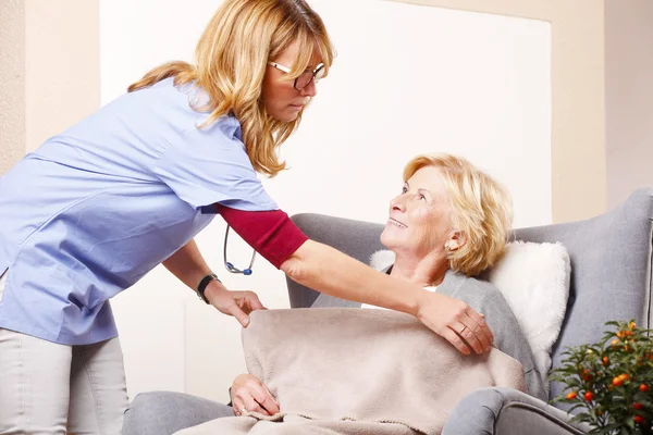 Krankenschwester kümmert sich um ältere Frau — Stockfoto