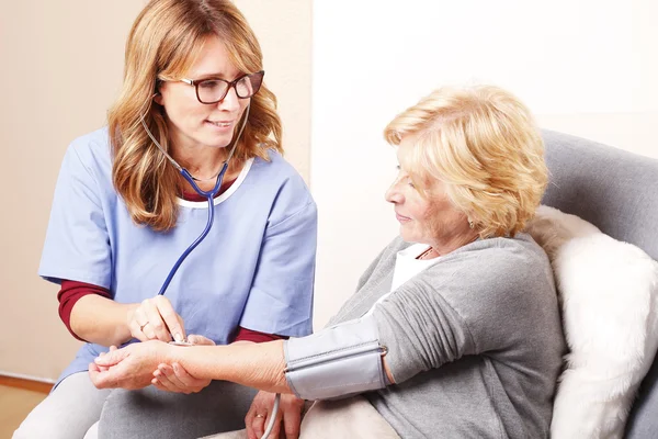 Krankenschwester überprüft Blutdruck — Stockfoto