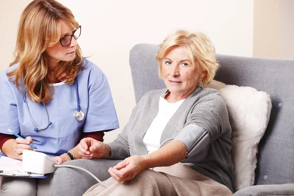 Nurse checking blood pressure — Stock Photo, Image