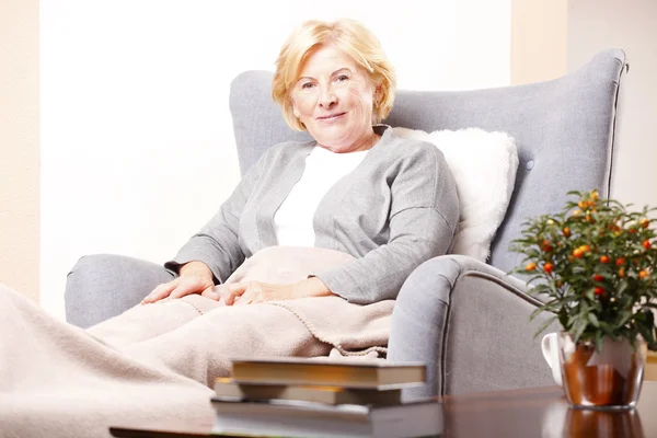 Vrouw in een fauteuil — Stockfoto