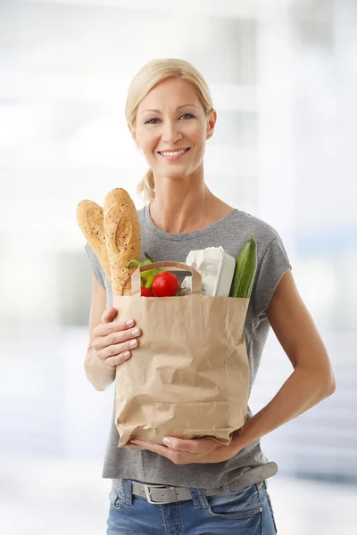 woman holding bag full of food