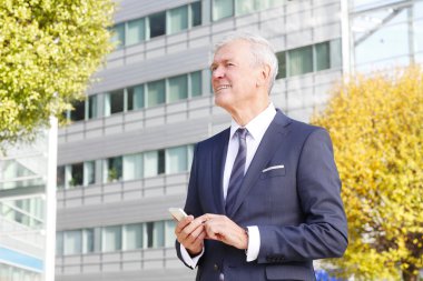 İş adamı cep telefonunu kullanıyor.