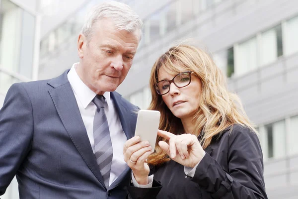 Empresaria sosteniendo en la mano su móvil — Foto de Stock