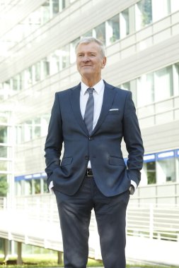 manager standing in front of office building.
