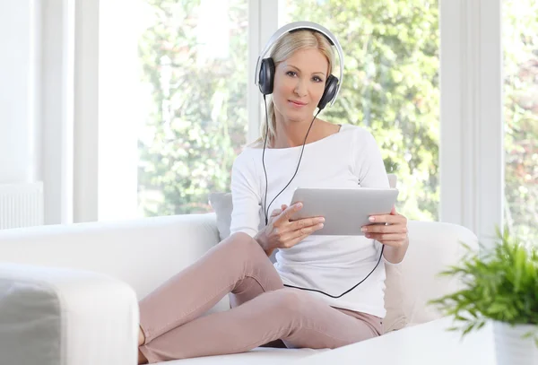 Vrouw die thuis naar muziek luistert — Stockfoto