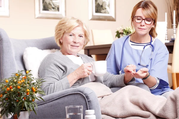 Home care nurse and giving medication — Stock Photo, Image