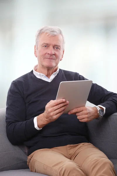 Homme âgé utilisant une tablette numérique. — Photo