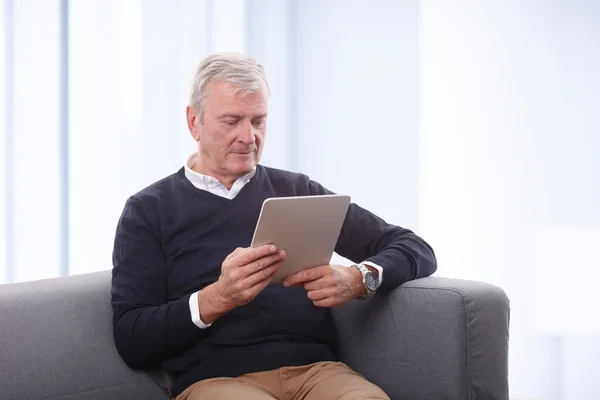 Senior man reading news — Stock fotografie
