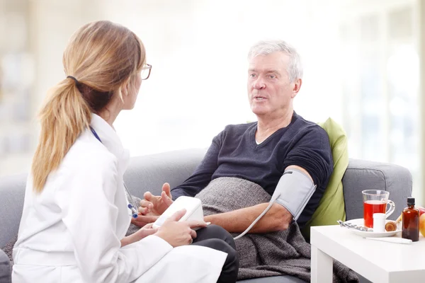 Medico che controlla la pressione sanguigna — Foto Stock