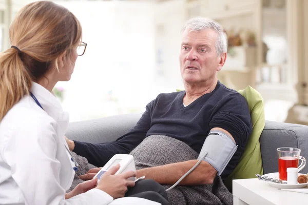 Médico que revisa la presión arterial —  Fotos de Stock