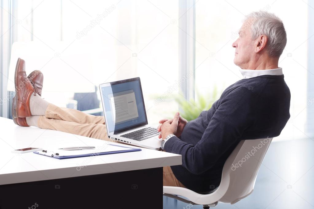 businessman with legs on desk